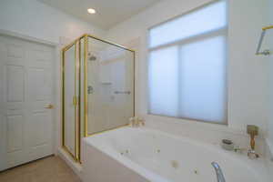 Bathroom with tile patterned flooring and independent shower and bath