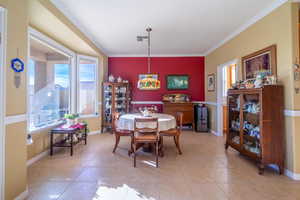 Dining space with light tile patterned floors and ornamental molding