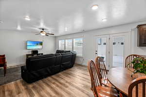 Living room with ceiling fan and light hardwood / wood-style floors