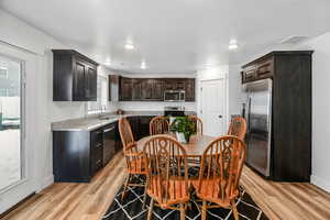 Kitchen featuring dark brown cabinetry, sink, light hardwood / wood-style flooring, and appliances with stainless steel finishes