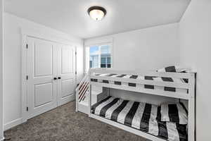 Bedroom with a closet and dark colored carpet