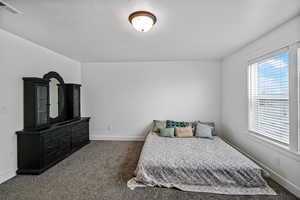 Bedroom featuring dark carpet