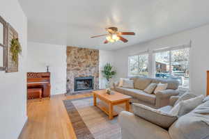 Living room with ceiling fan,bamboo floors and a wood burning fireplace