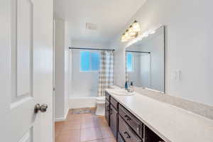 Full bathroom featuring tile patterned floors, vanity, shower / tub combo, and toilet