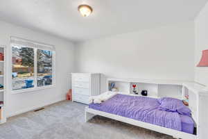 Bedroom featuring light carpet