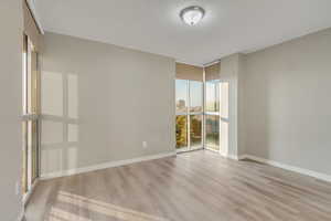 Unfurnished room with light hardwood / wood-style flooring, expansive windows, and a textured ceiling