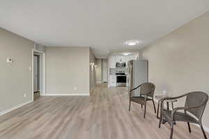 Sitting room featuring light wood-type flooring and a textured ceiling