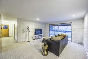 Living room featuring baseboard heating and brick wall