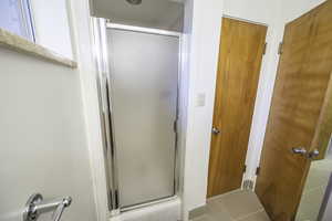 Bathroom featuring tile patterned flooring and a shower with door