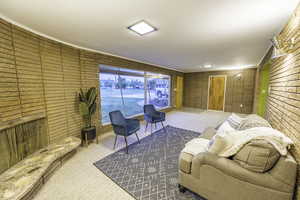 Carpeted living room with brick wall