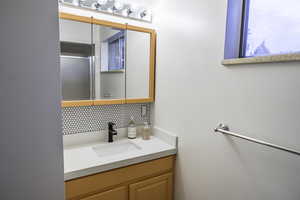 Bathroom featuring decorative backsplash and vanity