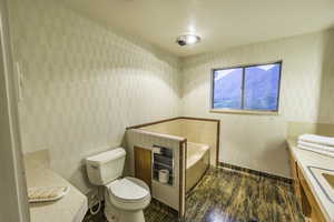 Bathroom with a bathing tub, vanity, and toilet