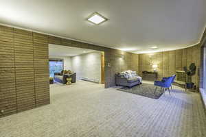 Carpeted living room featuring a baseboard heating unit