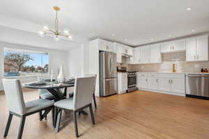 Dining room with a chandelier, light hardwood / wood-style flooring, and sink