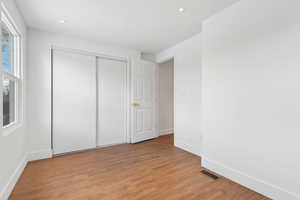 Unfurnished bedroom featuring a closet and light wood-type flooring