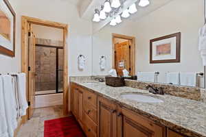 Basement Bathroom with double vanity and enclosed tub / shower combo