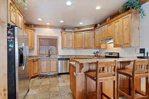 Kitchen with a breakfast bar area, kitchen peninsula, and stainless steel appliances