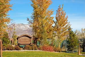 Community sign featuring a lawn and a mountain view