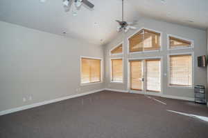 Club House Spare room with ceiling fan, dark carpet, and high vaulted ceiling