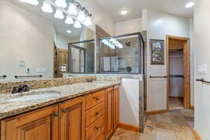 Master bathroom with vanity and a shower with door