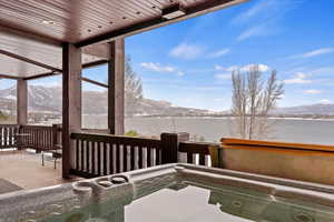 Patio... Views of Lake featuring a mountain view, plenty of natural light, and a hot tub