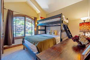 Bedroom with lofted ceiling and carpet floors