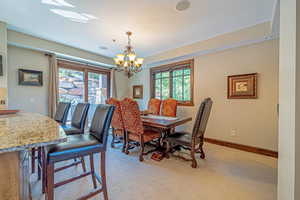 Dining space with a chandelier and light colored carpet