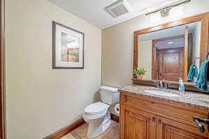 Bathroom featuring tile patterned flooring, vanity, and toilet