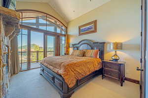 Bedroom featuring access to exterior, a mountain view, light carpet, and lofted ceiling