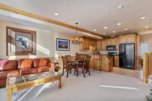 Interior space with a textured ceiling, crown molding, and a notable chandelier