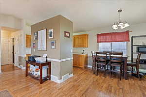 Kitchen featuring a notable chandelier, light hardwood / wood-style floors, and decorative light fixtures