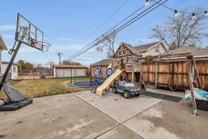 Exterior space featuring a playground and a trampoline