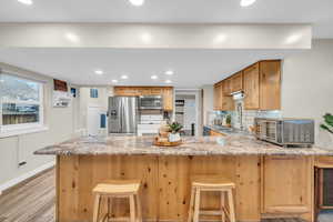 Kitchen with backsplash, sink, a breakfast bar area, kitchen peninsula, and stainless steel appliances