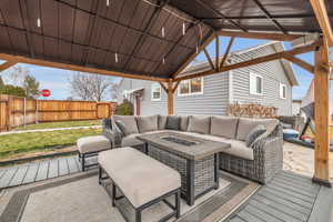 Wooden deck with a gazebo and an outdoor living space with a fire pit