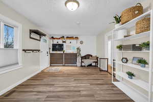 Living area featuring a textured ceiling and light hardwood / wood-style flooring