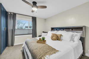 Carpeted bedroom featuring ceiling fan