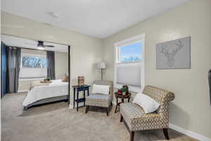 Carpeted bedroom featuring ceiling fan