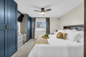 Carpeted bedroom featuring ceiling fan