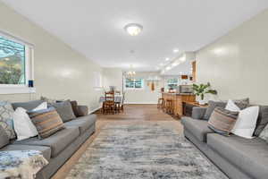 Living room featuring a chandelier, light hardwood / wood-style floors, and a healthy amount of sunlight