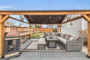 Wooden terrace featuring an outdoor living space with a fire pit