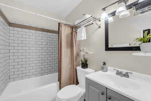 Full bathroom featuring vanity, toilet, and shower / bath combo with shower curtain