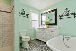 Full bathroom featuring tile patterned floors, a textured ceiling, toilet, vanity, and independent shower and bath