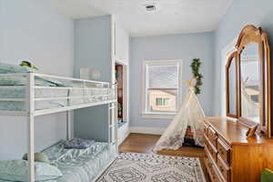 Bedroom with light hardwood / wood-style flooring and a textured ceiling