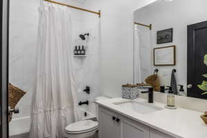 Full bathroom with shower / tub combo, vanity, and toilet