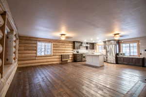 Unfurnished living room with hardwood / wood-style flooring and log walls