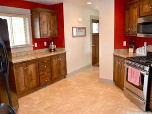 Kitchen featuring light tile patterned flooring and stainless steel appliances