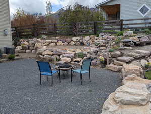 View of yard featuring fence, a patio, cooling unit, and an outdoor fire pit