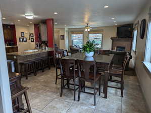 Dining area with light tile patterned floors, a textured ceiling, ceiling fan, and sink