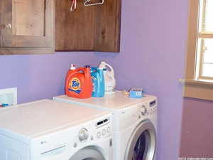 Washroom with cabinets and independent washer and dryer