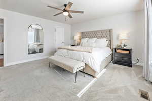 Carpeted bedroom featuring ceiling fan